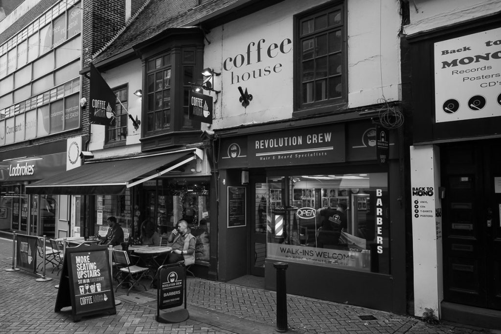 Local coffee shop Cafe Aroma just off Lincoln High Street by the Stonebow.  Two people can be seen sat outside drinking coffee.