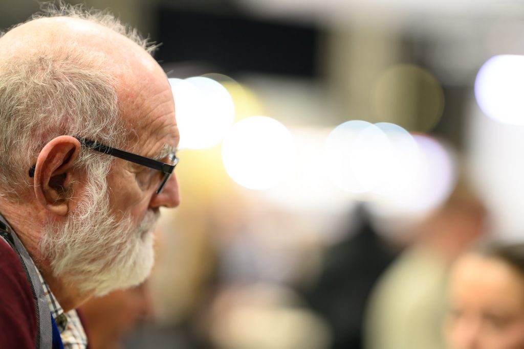 Portrait at a trade stand taken with a Nikkor 135mm f/1.8 lens wide open.