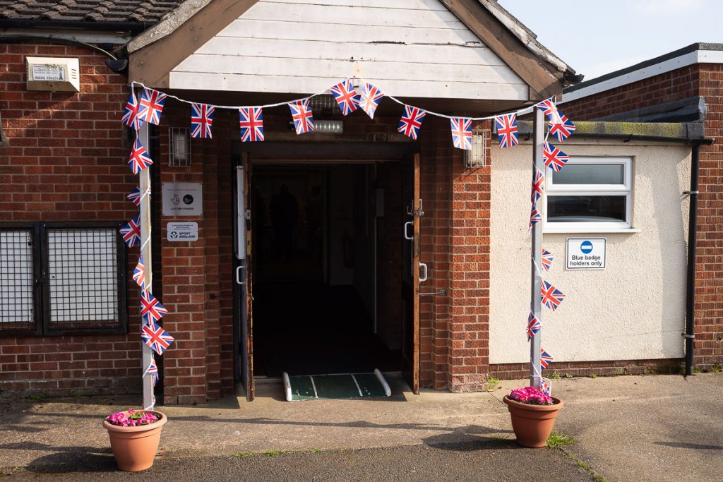 Entrance to the village hall. Union flags are around the entrance.