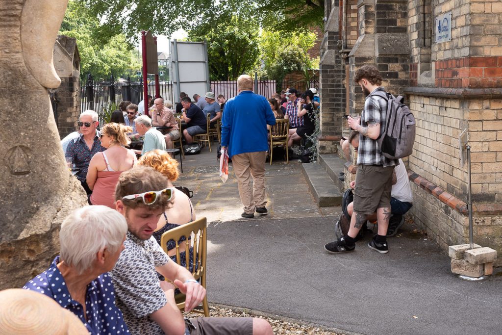 Beer festival attendees enjoying there drinks in the front outside area of the old church.
