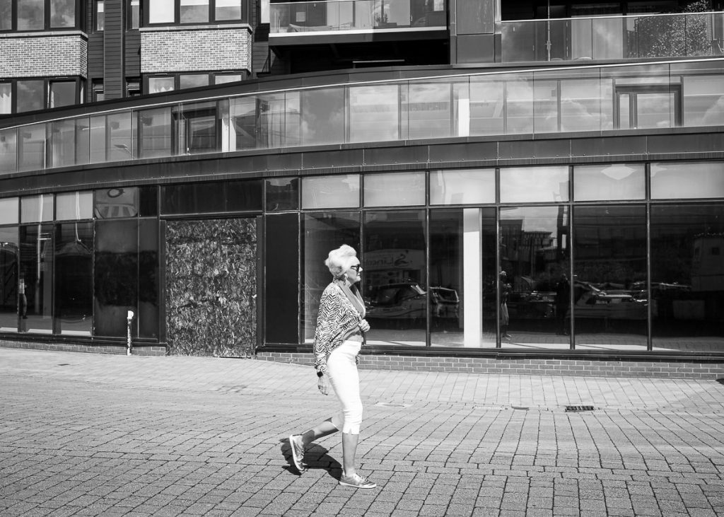 Woman walking past modern shop front.