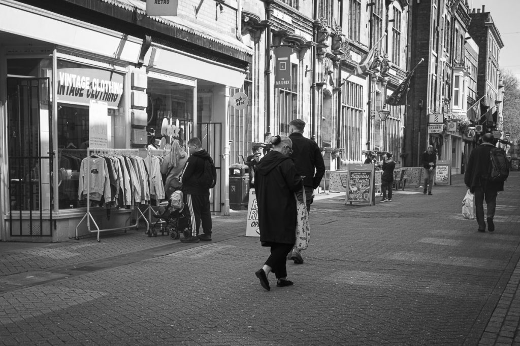 Old vintage shop with people walking past.