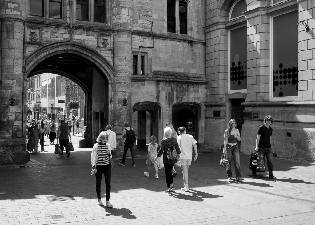 Guild Hall area of Lincoln, the Stonebow arch can be seen as people on the high street walk through it.