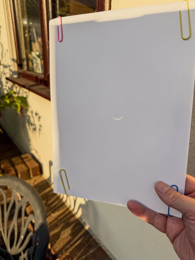 Piece of white paper, with a project from a pinhole showing the eclipse of the sun