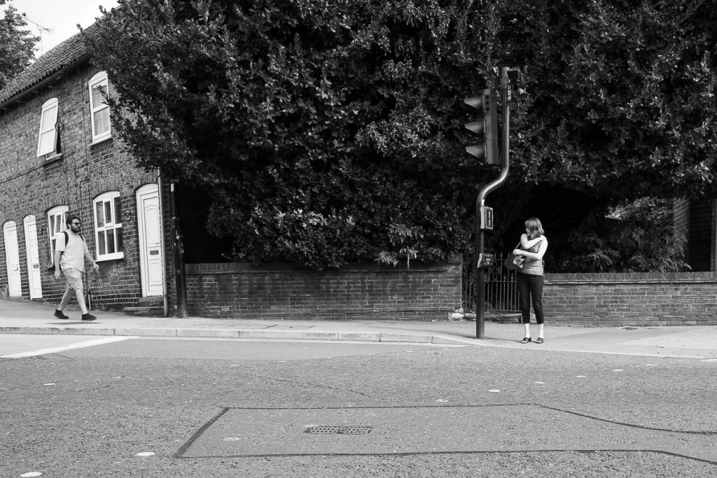 Waiting for the crossing. A typical scene in a semi rural town. A woman waits at a crossing for the signal to cross