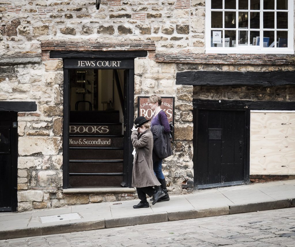 Young mum and child walking past Jews Court on Steep Hill in Lincoln